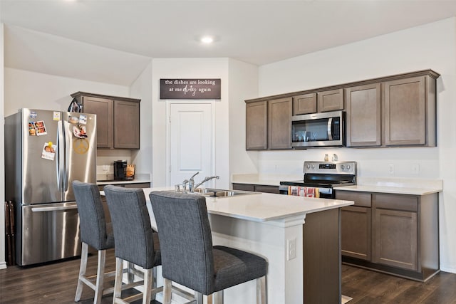 2802 Elk Rd, Crandall, TX 75114 - kitchen with appliances with stainless steel finishes, a sink, a kitchen island with sink, dark brown cabinetry, and dark wood finished floors
