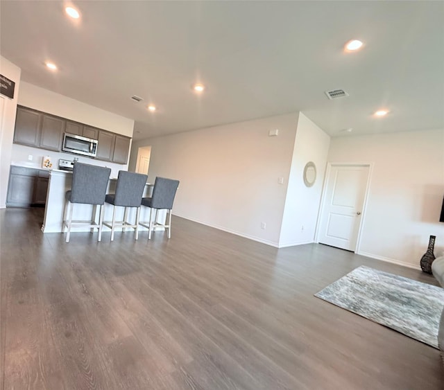 living area with recessed lighting, baseboards, visible vents, and dark wood-type flooring