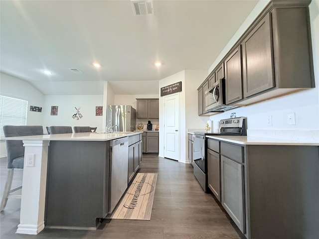 kitchen featuring a kitchen island with sink, stainless steel appliances, recessed lighting, and dark wood-type flooring