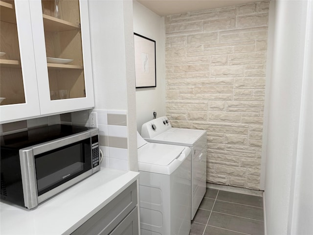 laundry room with washer and dryer, dark tile patterned floors, and laundry area