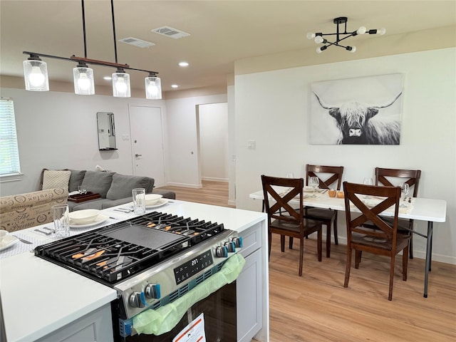kitchen with visible vents, stainless steel range with gas stovetop, and light wood finished floors