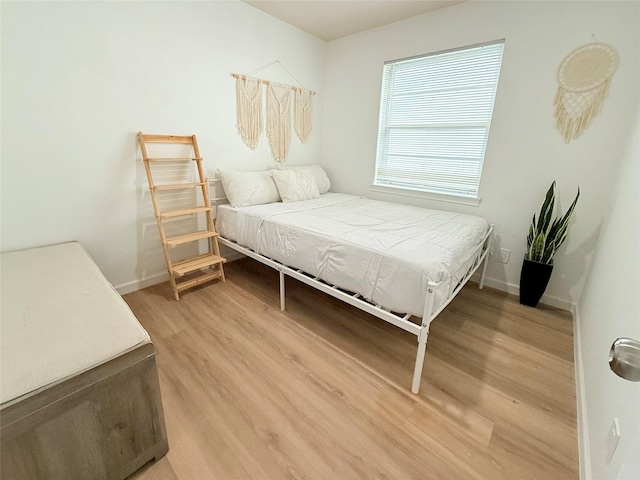 bedroom with baseboards and light wood finished floors