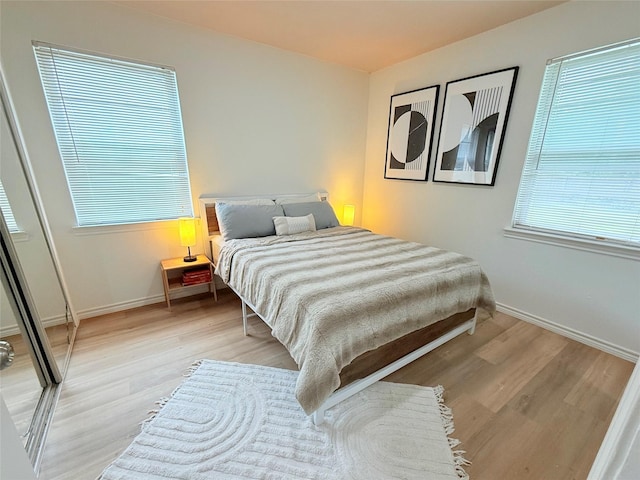 bedroom with light wood-style flooring and baseboards