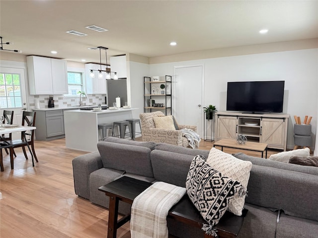 living room featuring visible vents, recessed lighting, and light wood finished floors