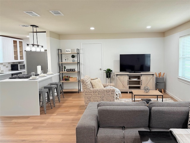 living area featuring visible vents, recessed lighting, and light wood-style flooring