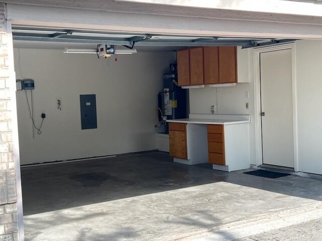 garage with secured water heater, a garage door opener, and electric panel