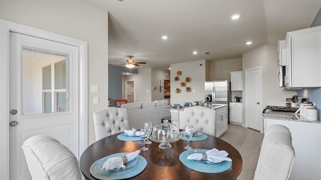 dining space featuring light wood-type flooring, a ceiling fan, and recessed lighting