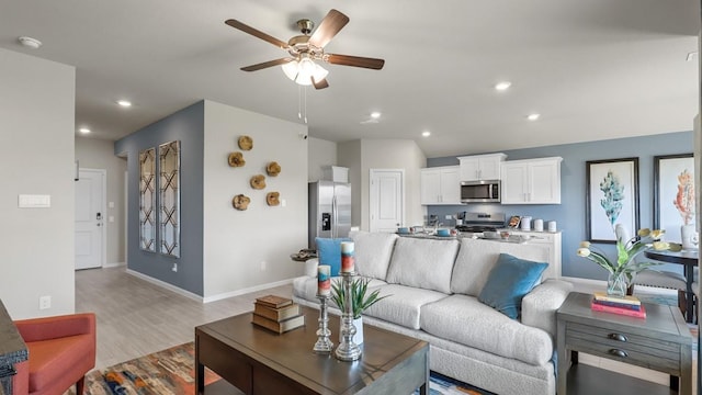 living room featuring a ceiling fan, light wood finished floors, recessed lighting, and baseboards