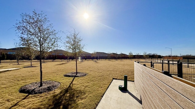 view of property's community featuring a yard and fence
