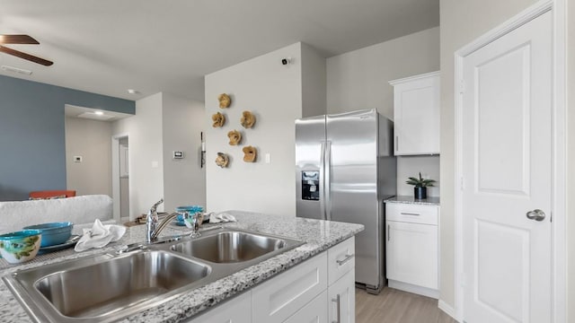 kitchen featuring a sink, white cabinetry, visible vents, stainless steel refrigerator with ice dispenser, and a ceiling fan