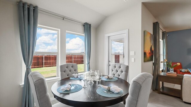 dining space with lofted ceiling and light wood-style flooring