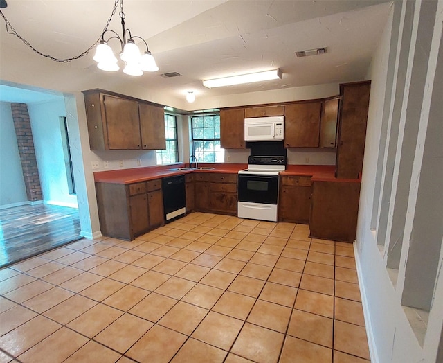 kitchen featuring white microwave, range with electric stovetop, light tile patterned floors, dishwasher, and visible vents