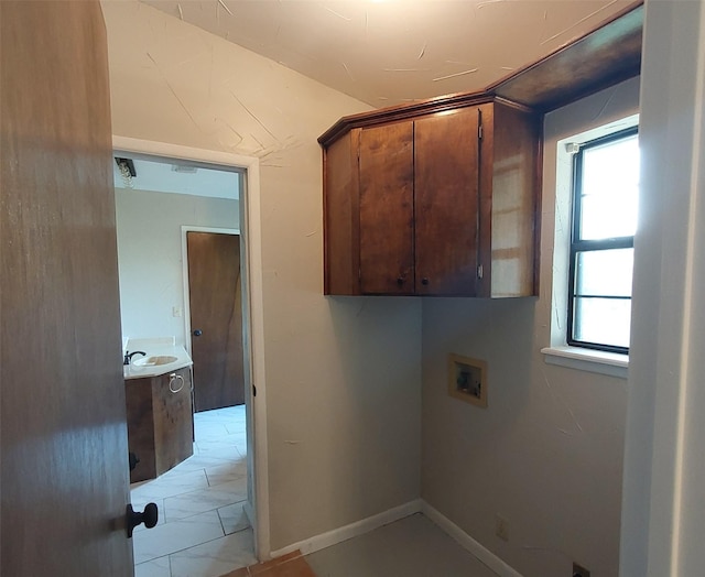 washroom with a sink, plenty of natural light, cabinet space, and washer hookup