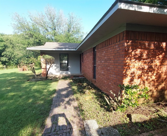 view of home's exterior featuring a lawn and brick siding