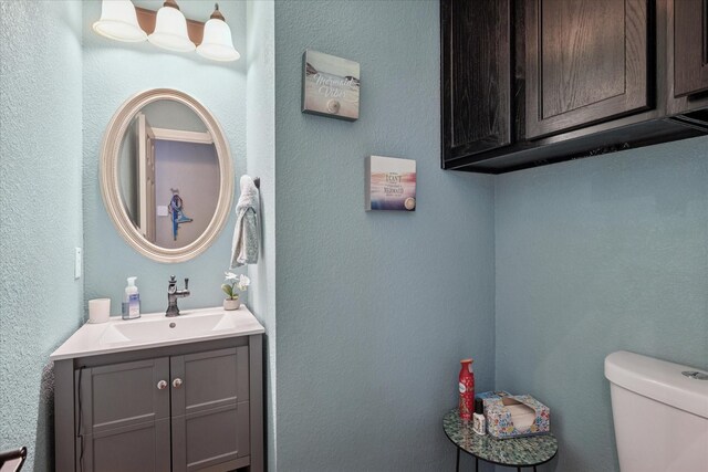 3001 Quail Holw, Mckinney, TX 75072 - half bath with vanity, toilet, and a textured wall