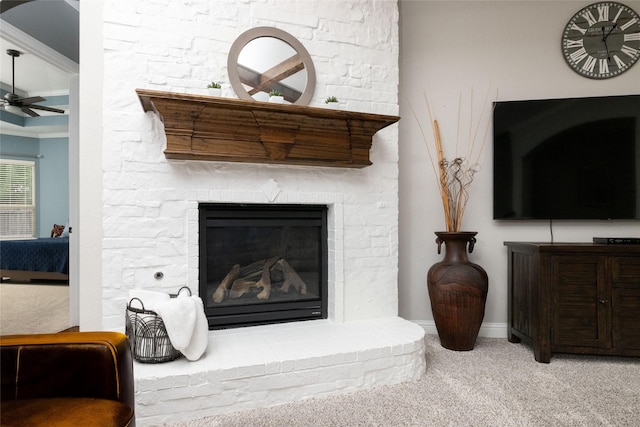 room details featuring carpet flooring, crown molding, a ceiling fan, a stone fireplace, and baseboards