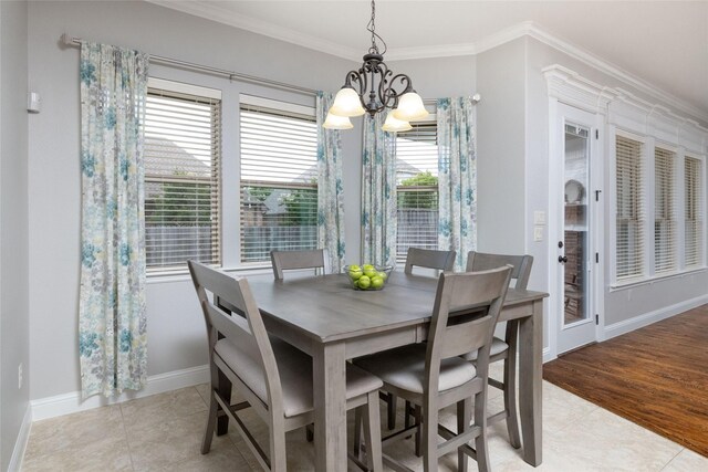 dining area with baseboards, ornamental molding, a notable chandelier, and light tile patterned flooring
