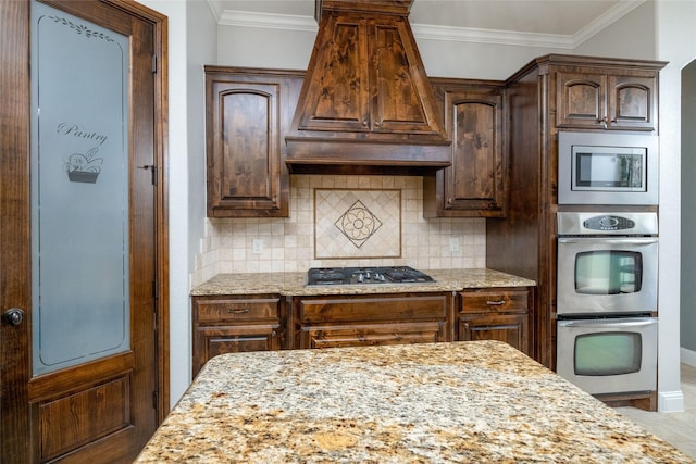 kitchen with tasteful backsplash, stainless steel appliances, light stone countertops, and ornamental molding