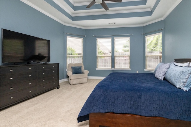 bedroom with light carpet, multiple windows, crown molding, and a tray ceiling