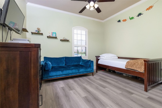 bedroom featuring wood finished floors, a ceiling fan, ornamental molding, and baseboards