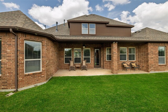 rear view of house with a lawn, a ceiling fan, a patio area, and brick siding
