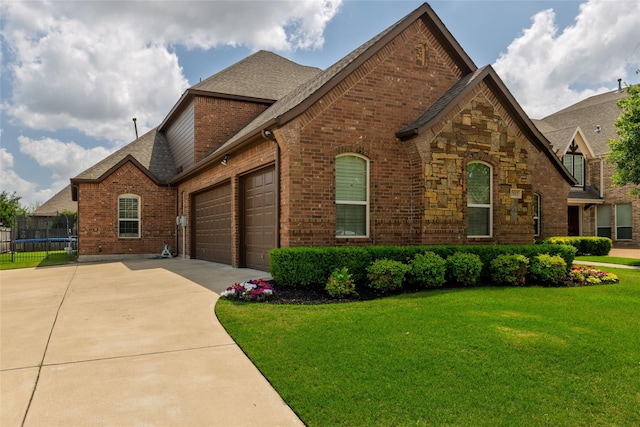 view of front of house featuring concrete driveway, a trampoline, a shingled roof, brick siding, and a garage