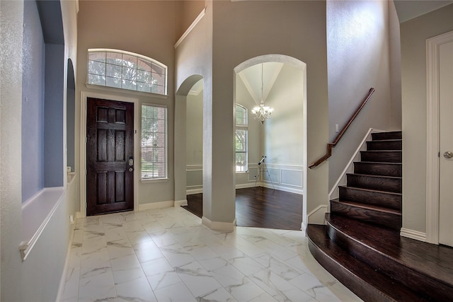 3509 New Castle Ct, Richardson, TX 75082 - foyer featuring a notable chandelier, arched walkways, stairs, and marble finish floor
