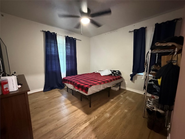 bedroom featuring baseboards, a ceiling fan, and wood finished floors