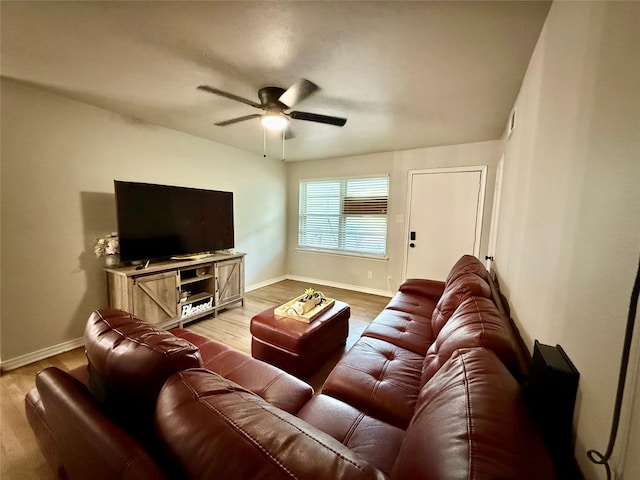 living room with light wood-style floors, baseboards, and a ceiling fan