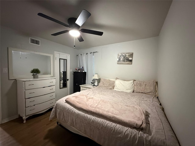 bedroom featuring visible vents, a ceiling fan, baseboards, and wood finished floors