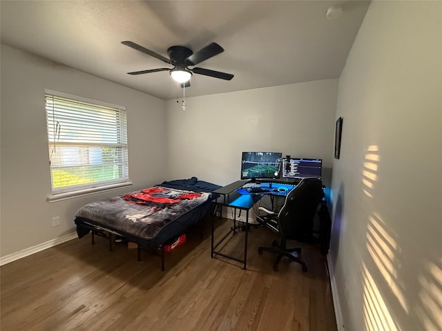 bedroom with baseboards, ceiling fan, and wood finished floors