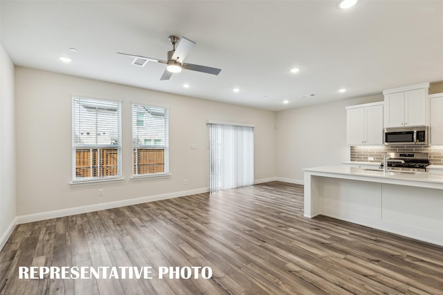 kitchen with light countertops, stainless steel appliances, a wealth of natural light, and backsplash