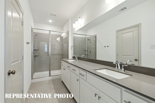 bathroom with double vanity, visible vents, a sink, and a stall shower