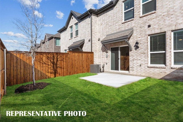 rear view of house featuring a yard, a patio, and a fenced backyard