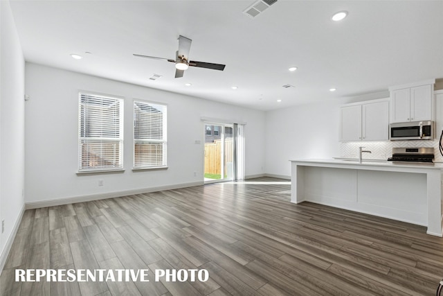 kitchen featuring stainless steel appliances, open floor plan, wood finished floors, and visible vents