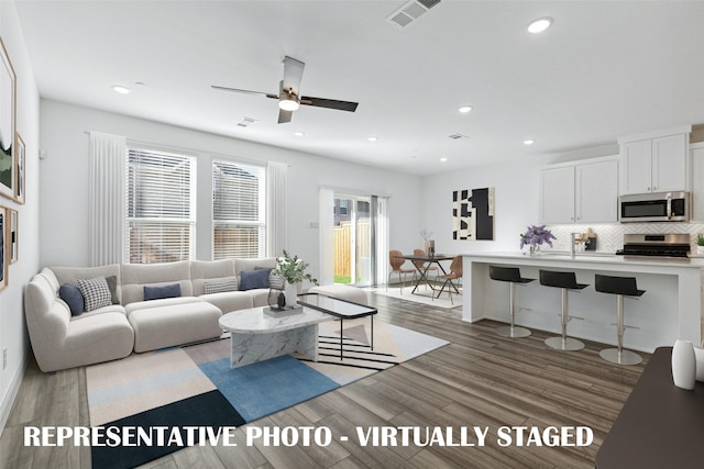 living room with visible vents, recessed lighting, ceiling fan, and wood finished floors