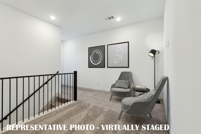sitting room featuring visible vents, carpet flooring, recessed lighting, and an upstairs landing