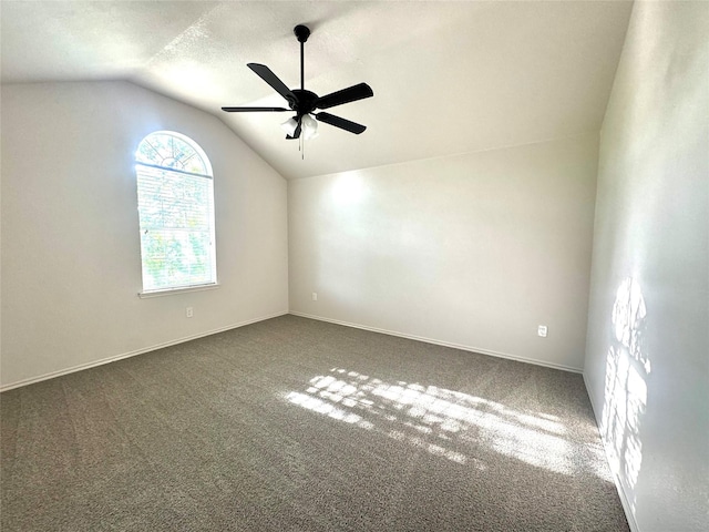 unfurnished room with carpet floors, ceiling fan, vaulted ceiling, and baseboards