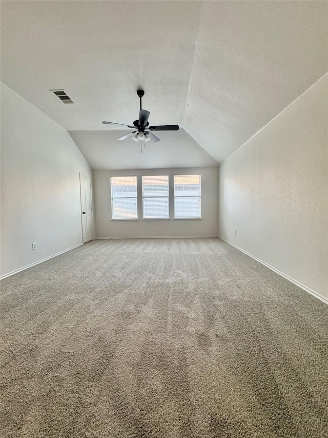 spare room with baseboards, visible vents, a ceiling fan, and lofted ceiling