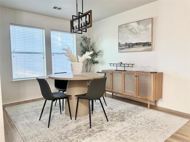 dining room with baseboards, plenty of natural light, wood finished floors, and visible vents