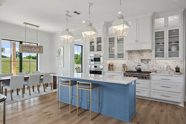 kitchen featuring white cabinetry, appliances with stainless steel finishes, decorative backsplash, and wood finished floors