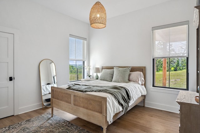 bedroom with baseboards and wood finished floors