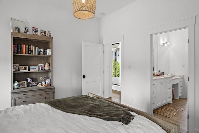 bedroom with ensuite bath and wood finished floors