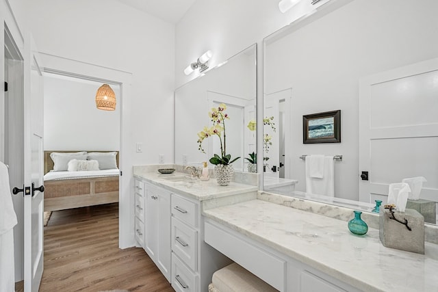 ensuite bathroom featuring wood finished floors, ensuite bath, and vanity