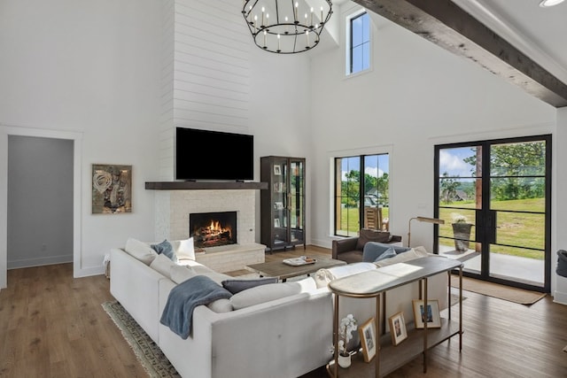 living room featuring baseboards, a chandelier, and a towering ceiling