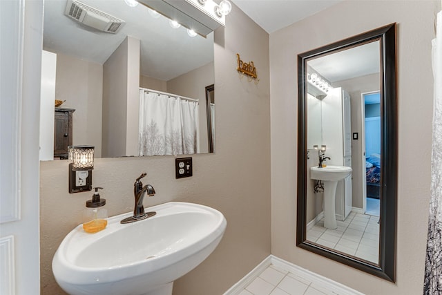 bathroom featuring a sink, tile patterned floors, baseboards, and visible vents