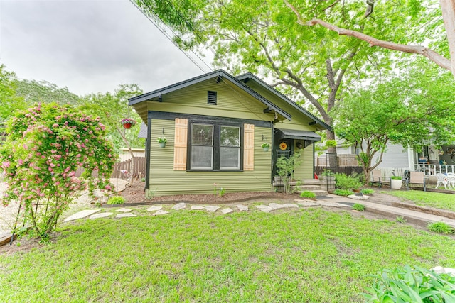 view of front of home featuring a front lawn and fence
