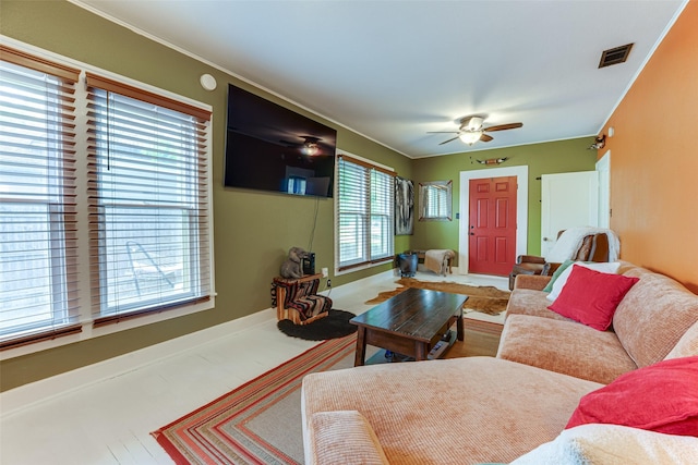 living area featuring ceiling fan, visible vents, and baseboards