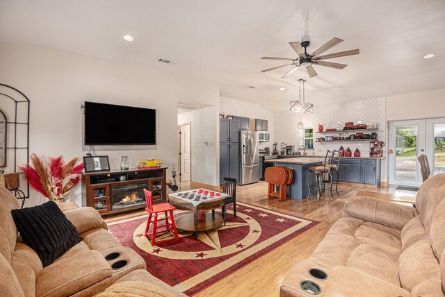 living room with ceiling fan, visible vents, vaulted ceiling, recessed lighting, and light wood-style flooring