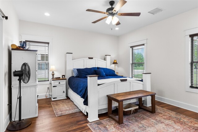 bedroom featuring baseboards, multiple windows, dark wood-style floors, and visible vents